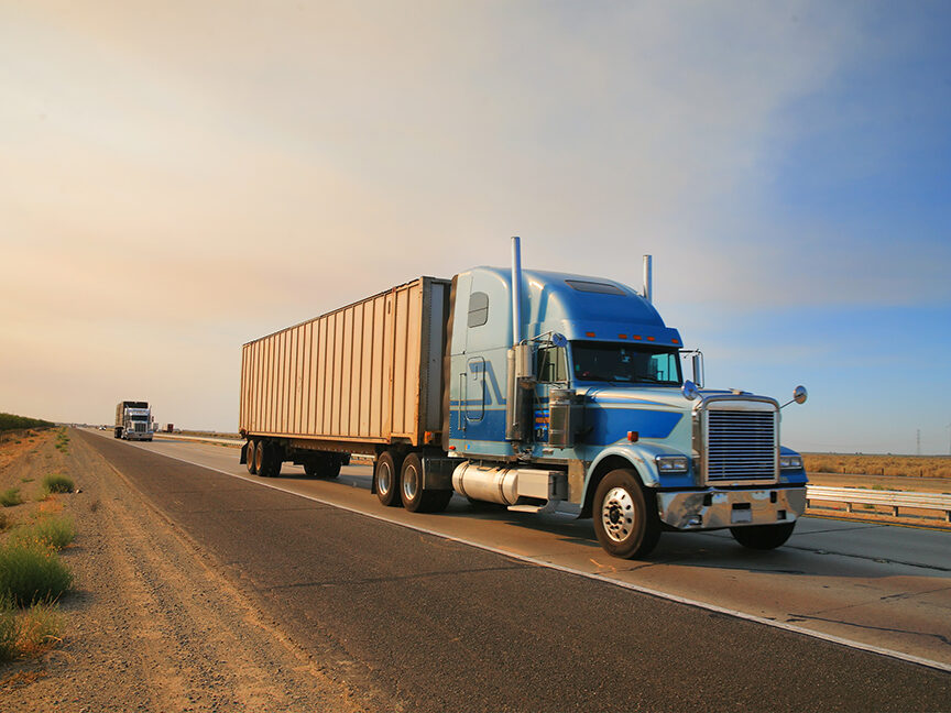 A diesel-powered 18-wheeler drives on the highway