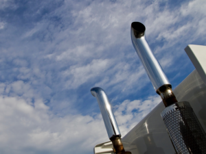 A photograph of a truck's exhaust pipes pointing skyward.