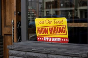 Photo of ad saying "we're hiring" in store window. Source: iStock