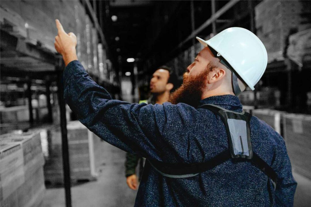 A worker wears a StrongArm sensor while working in a warehouse.