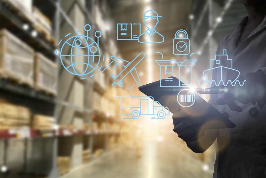 A GRAPHIC SHOWING MULTIPLE TRANSPORTATION MODE ICONS SUPERIMPOSED ON A PHOTO OF A PERSON WITH A TABLET COMPUTER IN A WAREHOUSEECHNOLOGY iStock-greenbutterfly-1363746705.jpg