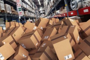 A MESSY JUMBLE OF BOXES SIT ON THE FLOOR OF A WAREHOUSE 