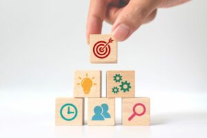 A HAND ARRANGES WOODEN BUILDING BLOCKS