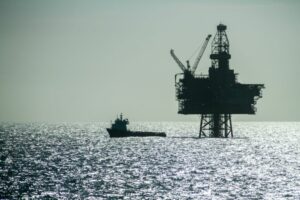 AN OFFSHORE OIL RIG STANDS SILHOUETTED BY THE SHINING LIGHT OF THE NORTH SEA 