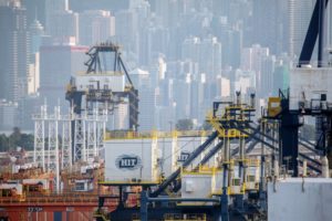 CRANES IN A PORT IN FRONT OF A MODERN CITY