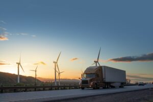 Semi truck speeding in front of Wind turbines