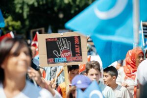 DEMONSTRATORS AT A RALLY HOLD SIGNS SAYING STOP THE GENOCIDE