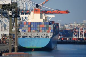 A GIANT CONTAINER SHIP SITS AT A DOCK