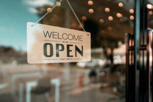 An open cafe or restaurant. An open sign board can be seen on the glass door of a modern cafe coffee shop.