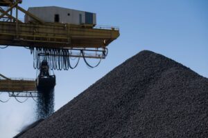 COAL POURS FROM A HOPPER ONTO A HUGE PILE