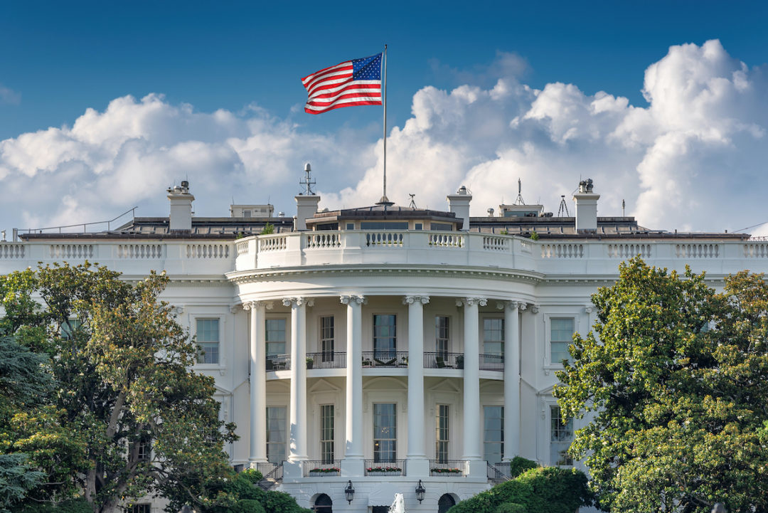 THE EXTERIOR OF THE WHITE HOUSE BELOW A CLOUDY BLUE SKY