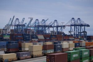 SHIPPING CONTAINERS AND BLUE CRANES CAN BE SEEN AT THE PORT OF LOS ANGELES.