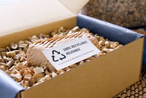 AN OPEN BOX FULL OF PAPER PACKAGING AND A LABEL THAT SAYS 100% REUSABLE RECYCLABLE