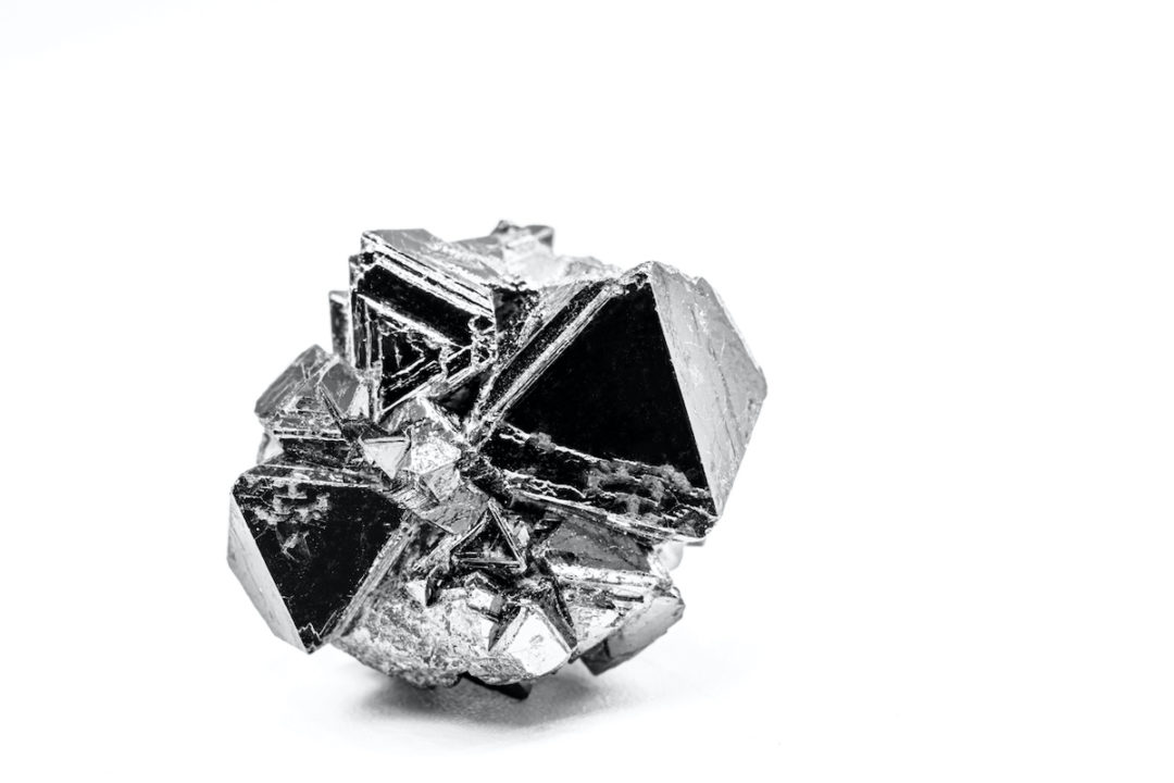 A LONE OSMIUM FRAGMENT SITS IN FRONT OF A WHITE BACKGROUND.