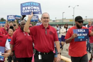 PEOPLE IN RED POLO SHIRTS HOLD UP SIGNS OF PROTEST