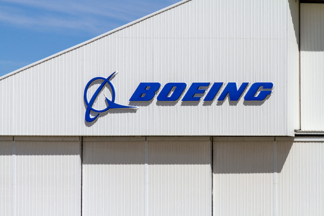 THE BOEING COMPANY LOGO CAN BE SEEN ON THE WALL OF A BUILDING WITH A BLUE SKY IN THE BACKGROUND.