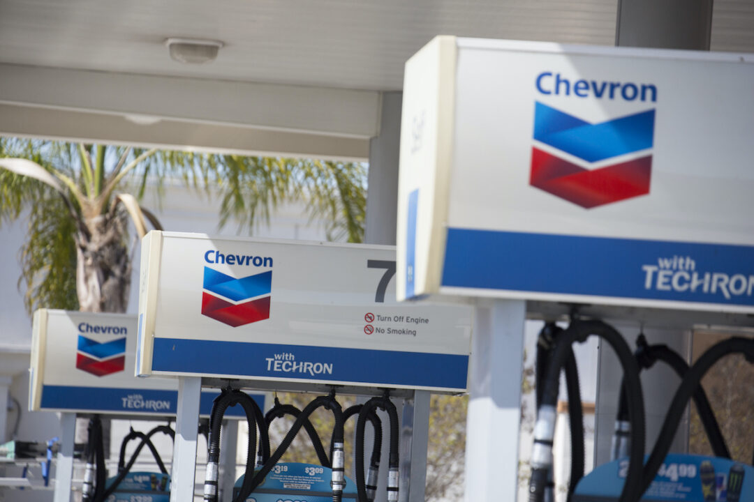 A CLOSE UP OF THREE GAS PUMPS THAT HAVE THE CHEVRON LOGO ON TOP OF THEM.