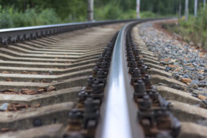 CLOSE-UP OF RAILROAD TRACKS WITH TREES IN THE BACKGROUND.