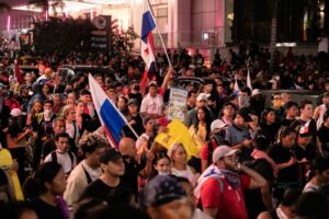 DEMONSTRATORS WITH FLAGS AND SIGNS BLOCK A ROAD IN PANAMA DURING A PROTEST.