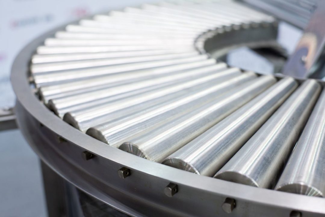 CLOSE UP OF A CURVED CONVEYOR SET OF ROLLERS