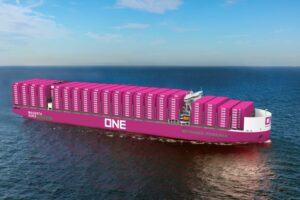 A MAGENTA PINK CONTAINER VESSEL ON THE OCEAN BEARS THE LETTERS ONE ON ITS SIDE