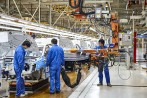 WORKERS INSTALL CAR PARTS ON AN ASSEMBLY LINE IN CHINA.