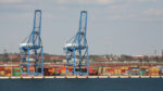 Cranes and shipping containers along the water at the Port of Baltimore.