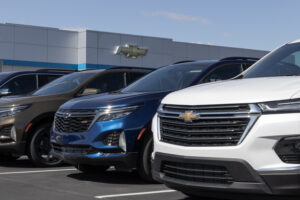 A row of General Motor trucks and SUVs outside of a dealership.