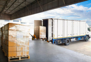 A truck being loaded with boxes in a warehouse.