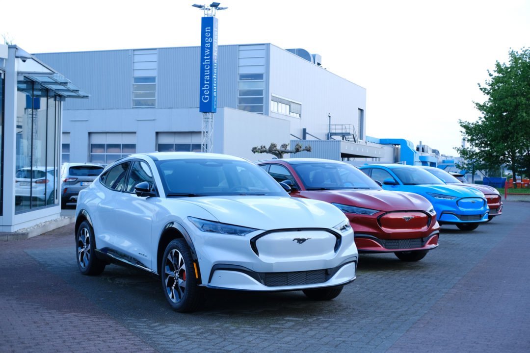 A row of Ford Mustangs parked outside of a dealership