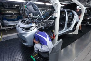 An autoworker assembling a car in a factory