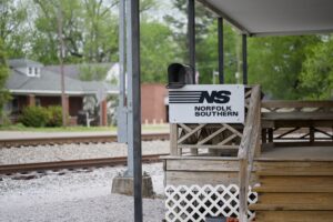 A Norfolk Southern sign on a porch outside a rail station