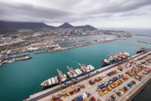 A PANORAMIC VIEW OF A HARBOR PORT, WITH MOUNTAINS BEHIND