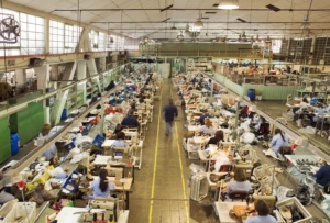 Workers in a shoe factory along an assembly line