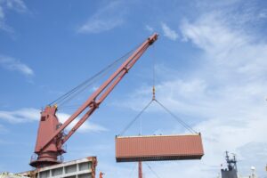 A ship-to-shore crane moving a container at a port