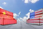 Containers with Chinese and U.S. flags stacked opposite each other in front of a blue sky
