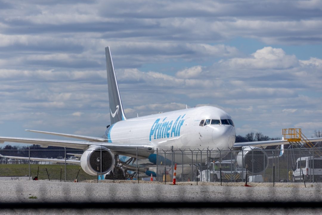 A front view of a white airplane with a "Prime Air" logo along the side and a dark blue tail