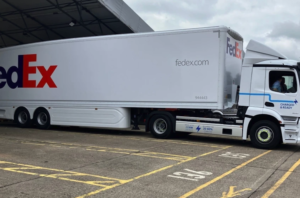 A long white FedEx truck and trailer viewed from the side