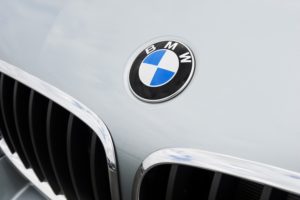 A close-up of a blue and white BMW emblem on the hood of a white car