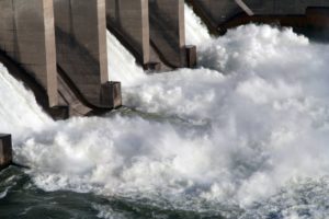 Water rushing out from a large concrete dam