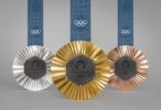 Silver, gold, and bronze Olympic medals from the 2024 Paris games, each with a hexagonal grey piece of iron embedded into the middle.