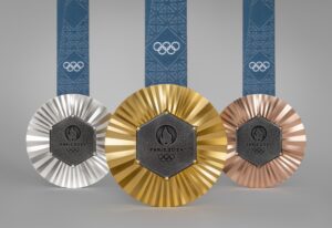 Silver, gold, and bronze Olympic medals from the 2024 Paris games, each with a hexagonal grey piece of iron embedded into the middle.