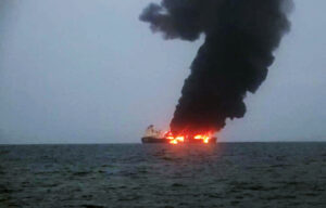 A LARGE SHIP ON THE HORIZON SPOUTS MASSIVE FLAMES