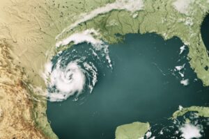 An overhead view of a map of the United States, with a swirling white visualization of a hurricane along the eastern coast of Texas