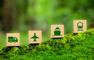 Four wooden blocks, each with a green icon representing Green transportation- a truck, plane, ship, and train. eco-friendly transportation, sustainable logistics.2154419802.jpg