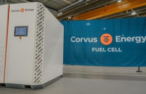 A large white cube with a "Corvus Energy" label, set against a blue screen in a warehouse