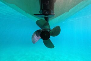 UNDERWATER, A LARGE RUDDER PROTRUDES FROM A SHIP'S HULL