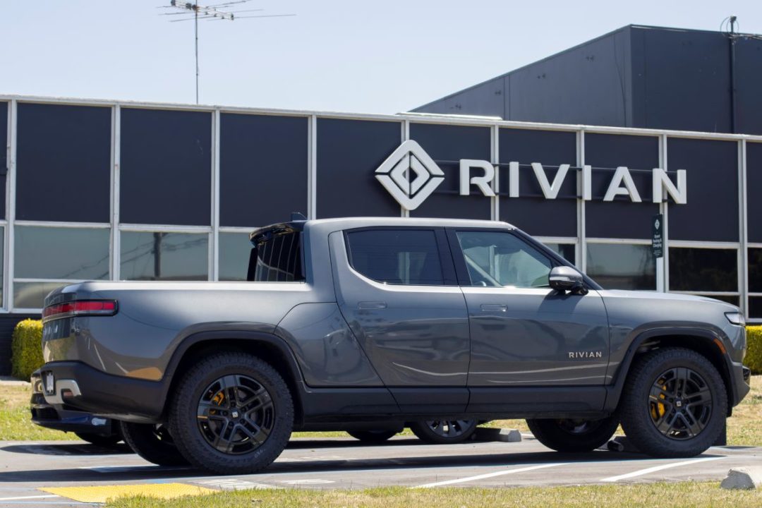 AN SUV TRUCK IS PARKED OUTSIDE AN OFFICE BUILDING BEARING THE RIVIAN LOGO049.jpg