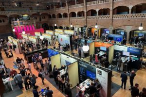 A GIANT HALL WITH GOTHIC BRICK ARCHES HOUSES DOZENS OF VENDOR BOOTHS