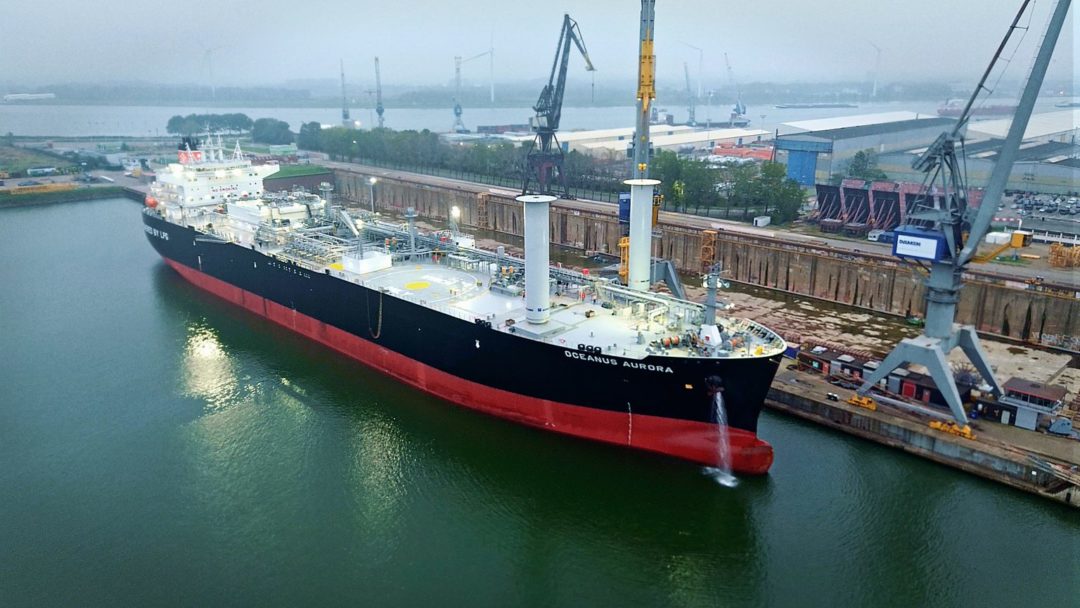 A LARGE TANKER SHIP SPORTS TWO UNUSUAL, UPRIGHT, CYLINDRICAL STRUCTURES TOWARD THE BOW END OF ITS DECK